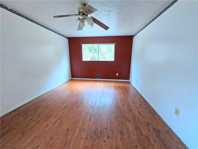 empty room featuring ceiling fan and hardwood / wood-style floors