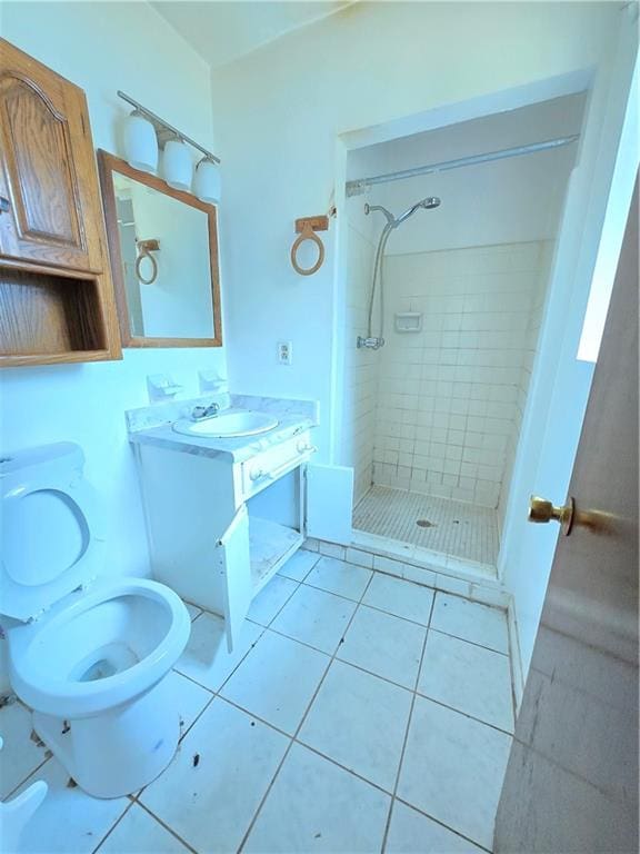 bathroom with vanity, a tile shower, tile patterned floors, and toilet