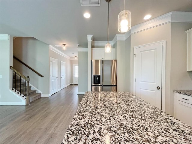 5119 Aylesbury Ct, Hoschton, GA 30548 - kitchen with light wood-type flooring, stainless steel fridge with ice dispenser, stone counters, visible vents, and white cabinets