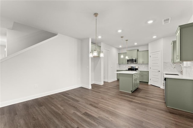 kitchen featuring a center island, green cabinets, visible vents, a sink, and stainless steel appliances