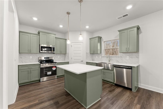 kitchen with a sink, green cabinetry, stainless steel appliances, visible vents, and light countertops