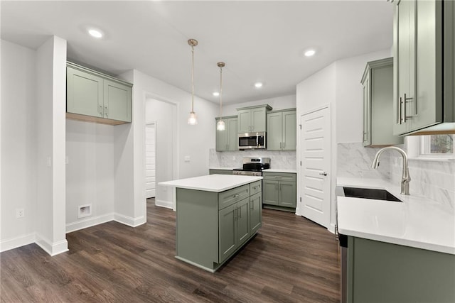 kitchen with a sink, a kitchen island, green cabinetry, stainless steel appliances, and dark wood-style floors