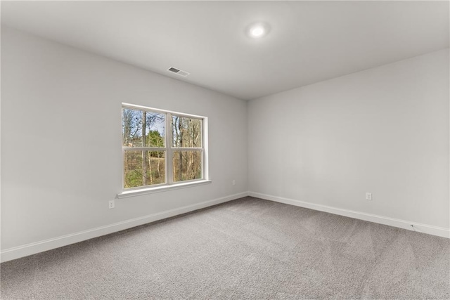 carpeted spare room featuring baseboards and visible vents