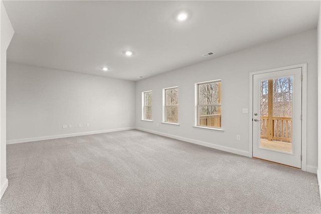 carpeted spare room with a wealth of natural light, baseboards, visible vents, and recessed lighting