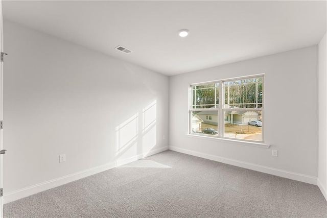 carpeted empty room featuring visible vents and baseboards
