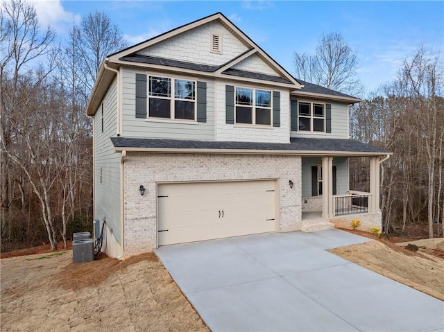 view of front of house with driveway, brick siding, covered porch, a garage, and roof with shingles