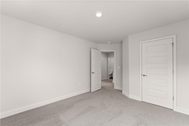 unfurnished bedroom with baseboards, light carpet, and recessed lighting