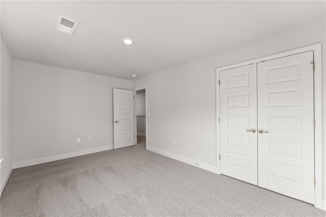 unfurnished bedroom featuring a closet, carpet floors, visible vents, baseboards, and recessed lighting