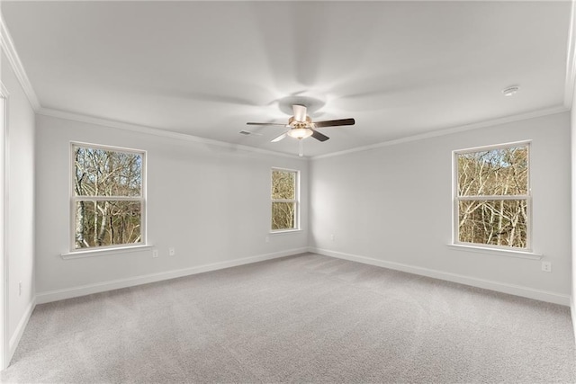 carpeted empty room with crown molding, baseboards, and a ceiling fan