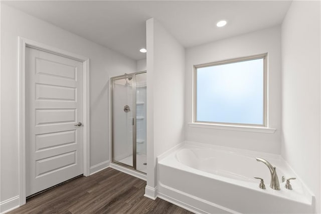 full bathroom featuring a shower stall, a garden tub, recessed lighting, and wood finished floors