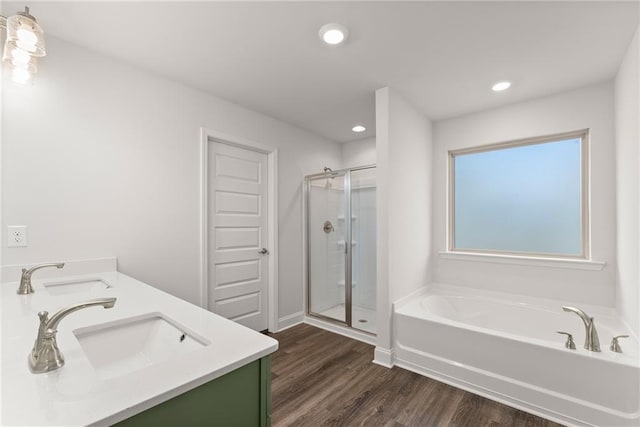 bathroom featuring a sink, wood finished floors, recessed lighting, a stall shower, and a bath