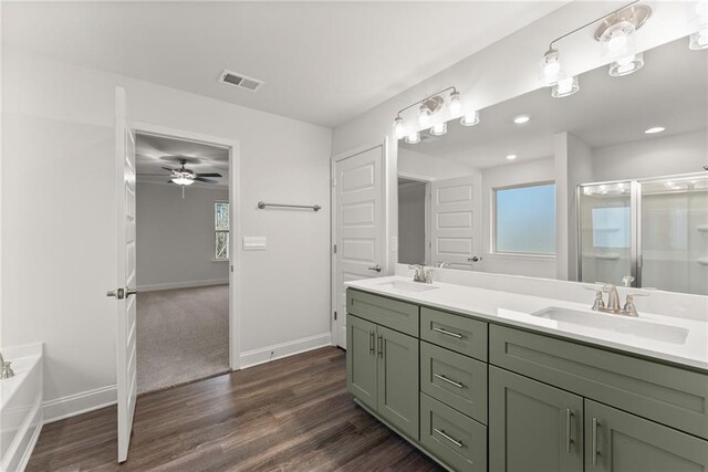 bathroom with a sink, a shower stall, visible vents, and wood finished floors
