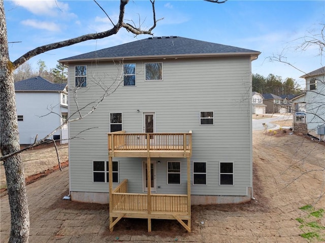 rear view of house with a deck and a balcony
