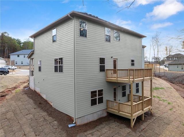back of house featuring a deck and a balcony