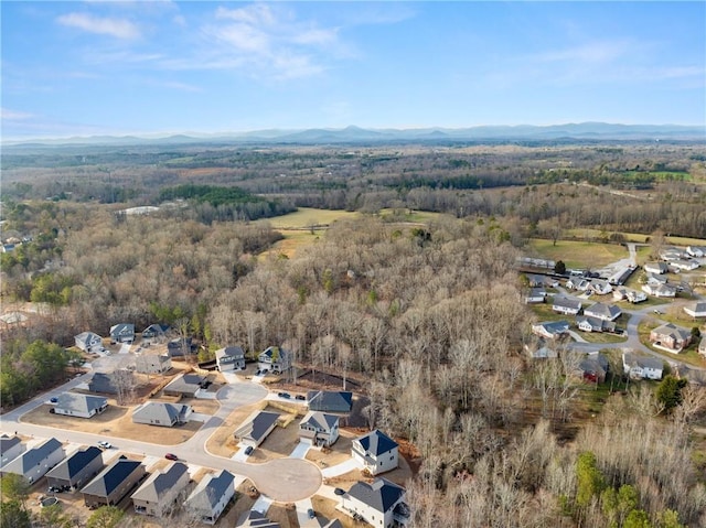 aerial view featuring a residential view, a wooded view, and a mountain view