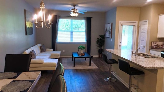 473 Broder Farms Dr, Stockbridge, GA 30281 - living room with dark wood-style floors, baseboards, a ceiling fan, and a chandelier
