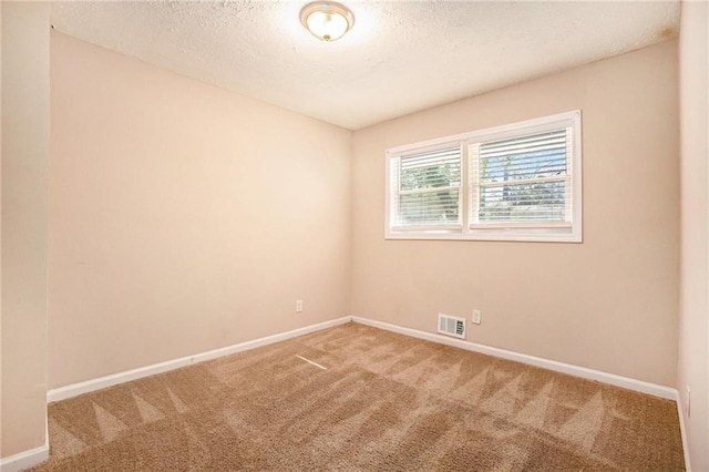 carpeted spare room featuring a textured ceiling