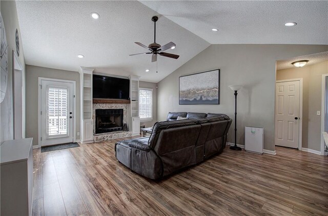 living room featuring a textured ceiling, plenty of natural light, and lofted ceiling