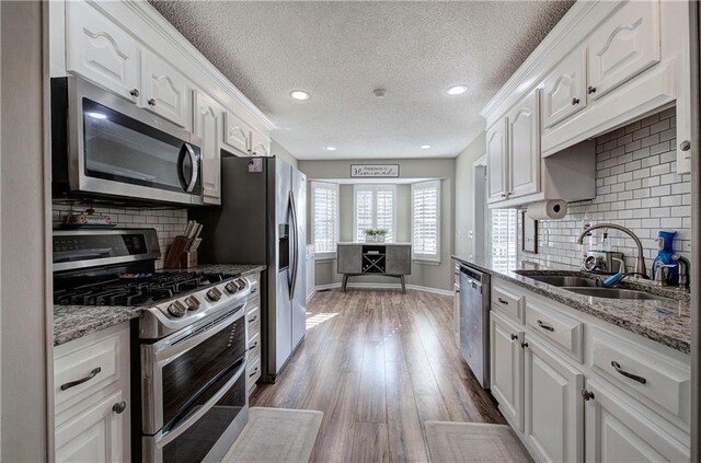 kitchen featuring backsplash, sink, white cabinetry, and stainless steel appliances