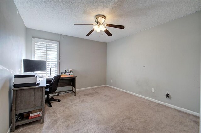 carpeted office space featuring ceiling fan and a textured ceiling