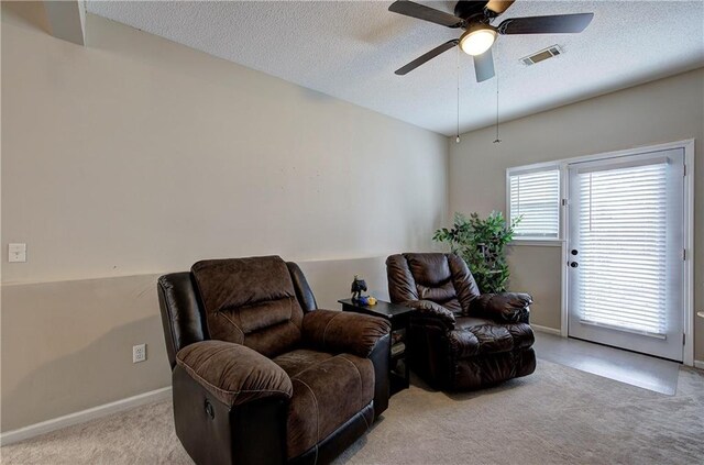 sitting room featuring ceiling fan, light carpet, and a textured ceiling