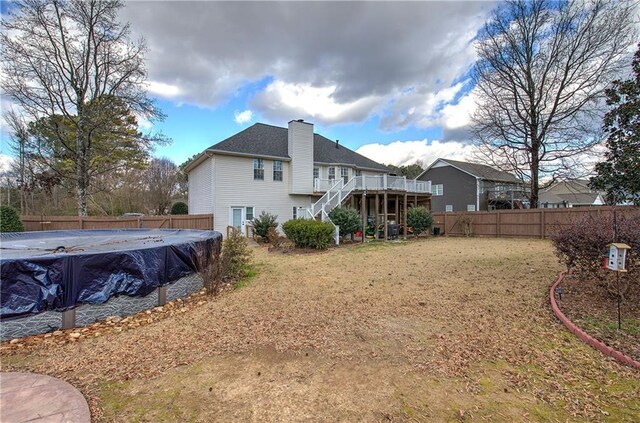 back of property featuring a lawn and a pool side deck