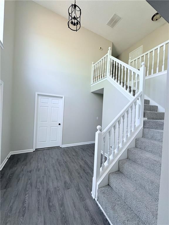 stairs featuring a towering ceiling and hardwood / wood-style floors