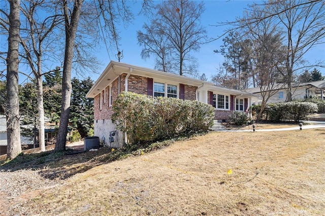 ranch-style house with a front yard, brick siding, and cooling unit