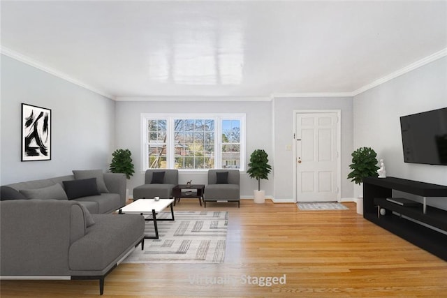 living area with light wood-style flooring, baseboards, and crown molding