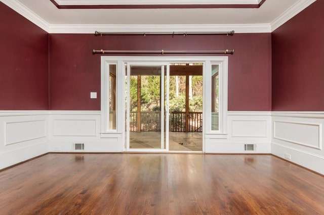 empty room with wood-type flooring and crown molding