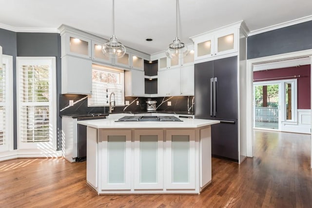 kitchen featuring backsplash, a center island, stainless steel appliances, and hanging light fixtures