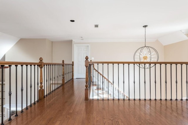 corridor featuring vaulted ceiling, dark hardwood / wood-style flooring, and an inviting chandelier