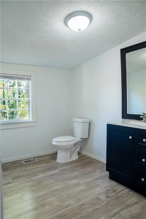 bathroom featuring a textured ceiling, vanity, and hardwood / wood-style flooring