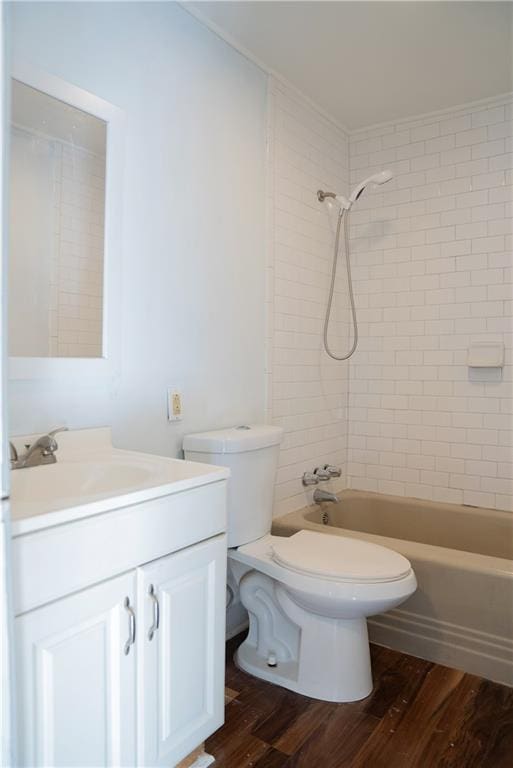 full bathroom with vanity, wood-type flooring, tiled shower / bath combo, and toilet