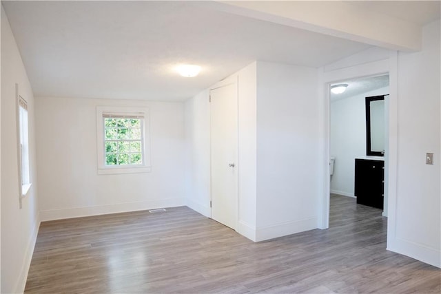 empty room featuring light hardwood / wood-style flooring and lofted ceiling