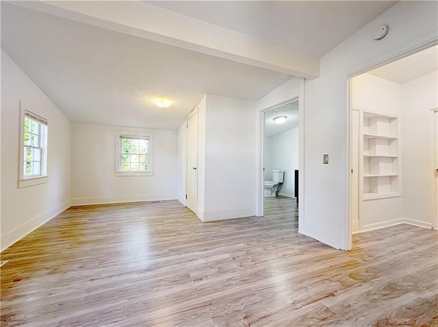 spare room featuring vaulted ceiling and light hardwood / wood-style flooring