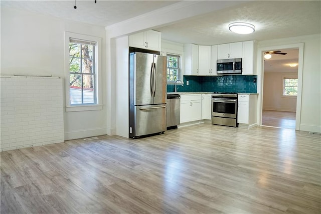 kitchen featuring white cabinets, stainless steel appliances, and light hardwood / wood-style floors