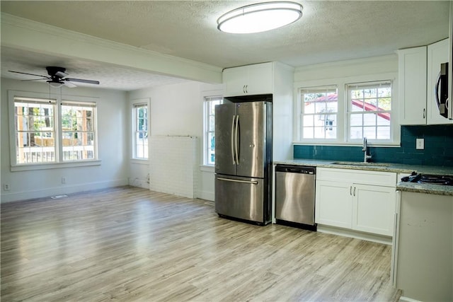 kitchen featuring light wood-type flooring, stainless steel appliances, white cabinetry, and sink