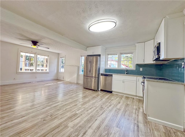 kitchen featuring white cabinets, light wood-type flooring, a textured ceiling, and appliances with stainless steel finishes