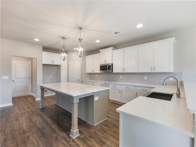 632 Eagles Nest Cir, Auburn, GA 30011 - kitchen with stainless steel microwave, visible vents, decorative backsplash, and a sink