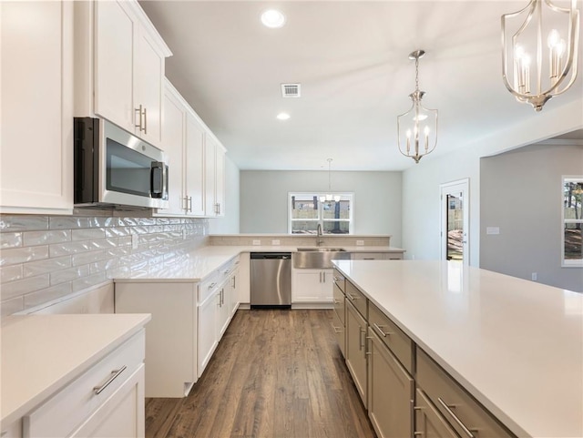 632 Eagles Nest Cir, Auburn, GA 30011 - kitchen with a sink, an inviting chandelier, backsplash, light countertops, and appliances with stainless steel finishes