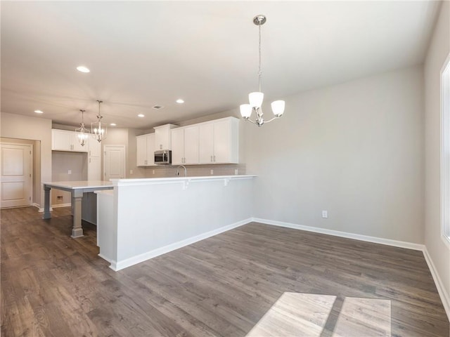 632 Eagles Nest Cir, Auburn, GA 30011 - kitchen featuring a peninsula, stainless steel microwave, recessed lighting, an inviting chandelier, and light countertops
