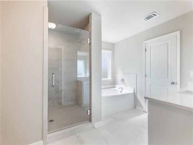 632 Eagles Nest Cir, Auburn, GA 30011 - bathroom featuring tile patterned floors, baseboards, visible vents, a stall shower, and a garden tub