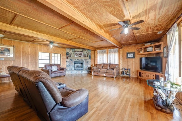 living room featuring wood walls, plenty of natural light, light wood-type flooring, and a fireplace