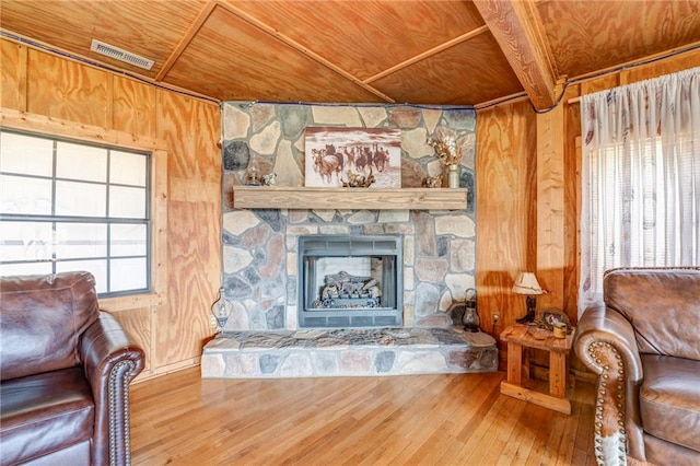 living room featuring wooden ceiling, hardwood / wood-style floors, wood walls, and a fireplace