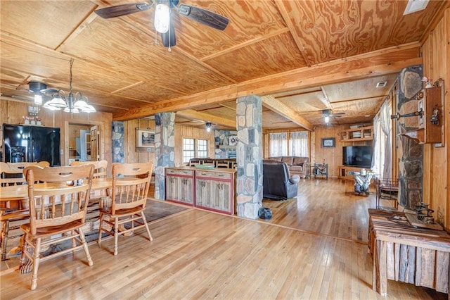 dining area featuring wooden walls, ceiling fan, and hardwood / wood-style floors