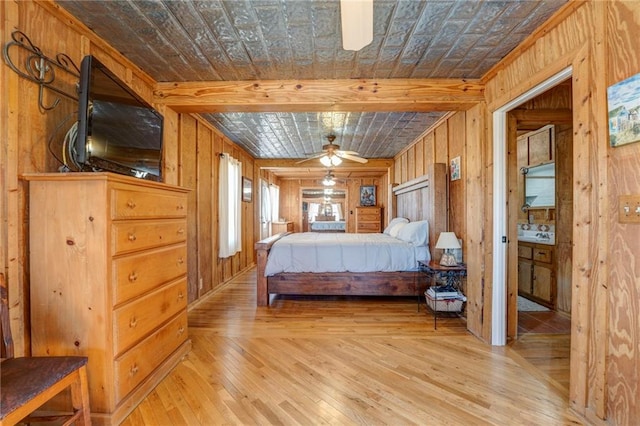 bedroom with wooden walls and light hardwood / wood-style flooring