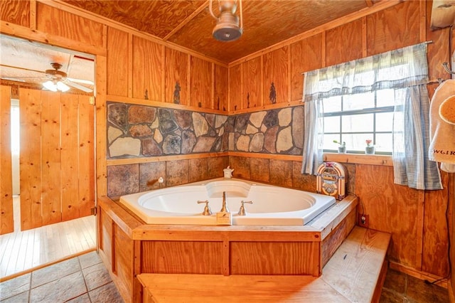 bathroom with wood walls, ceiling fan, and a bathing tub