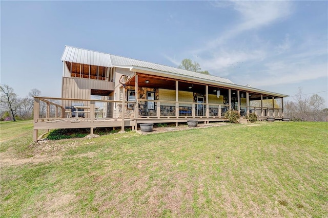 rear view of property featuring a wooden deck and a yard