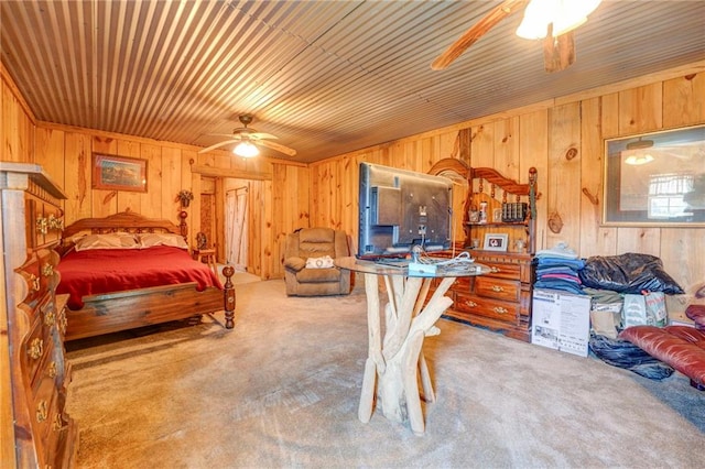 carpeted bedroom featuring wooden walls, ceiling fan, and wooden ceiling